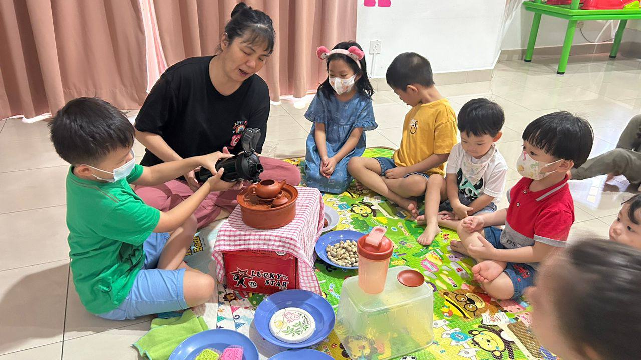 Children taking part in a hands-on cultural activity with a member of the Dloving Care and Learning Team