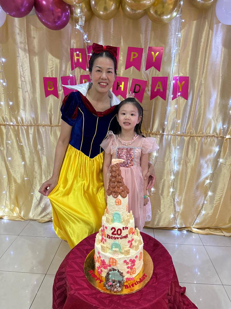 Yvonne celebrating Dloving's twentieth anniversary with a child